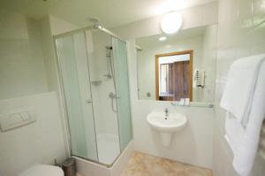a bathroom with a glass shower and a sink at Hotel A4 MOP Zastawie in Jaworzno