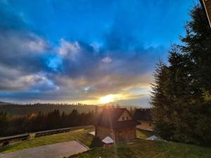 a view of the sun setting over a house at Koniakowo - dom Fino in Koniaków