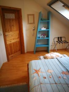 a bedroom with a bed and a blue book shelf at Gästehaus Nord-West 1700 - Doppelzimmer Seestern in Steenfeld