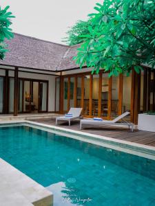 a villa with a swimming pool and a house at Ningaloo Villa in Gili Trawangan