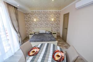een slaapkamer met een bed en een tafel en stoelen bij Парк-отель Коттеджи Меркурий in Gribovka