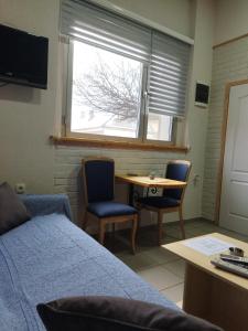 Cette chambre comprend un lit, une table et une fenêtre. dans l'établissement Apartmani Sirmium, à Sremska Mitrovica