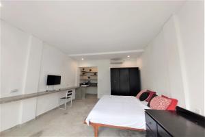 sypialnia z białym łóżkiem i telewizorem w obiekcie Margarita Surf Hostel w mieście Canggu