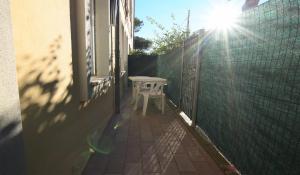 un petit tabouret blanc posé sur le côté d'un bâtiment dans l'établissement Primavera, à Marina di Campo