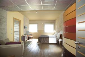 Habitación de hotel con cama y sofá en Albergo Cantine Ascheri en Bra