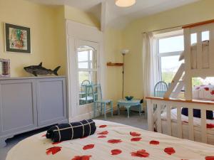Un dormitorio con una cama y una habitación con ventana. en BRYN GORS-3 BED-FIRST FLOOR APT- YARDS FROM BEACH, en Trearddur