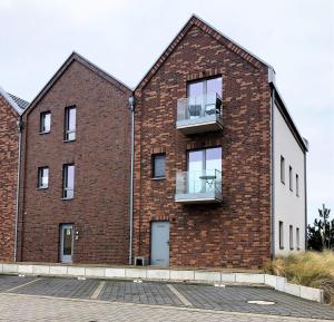 a brick building with a balcony on the side at Strandresort Heiligenhafen Strandresort 47 in Heiligenhafen