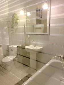 a bathroom with a toilet and a sink and a tub at La Maison de Thaïs in Arles