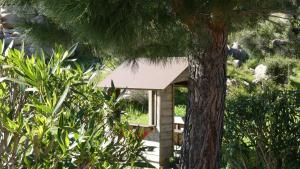 a small house with a white roof next to a tree at Résidence Santa Monica in Bonifacio