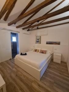 a bedroom with a large white bed and wooden floors at Dos Torres Rivendel - Vistas a la Basílica del Pilar in Zaragoza