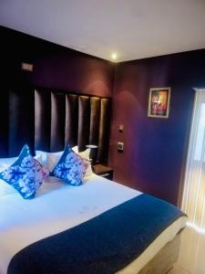 a bedroom with a large bed with blue pillows at Thavhani boutique hotel in Thohoyandou