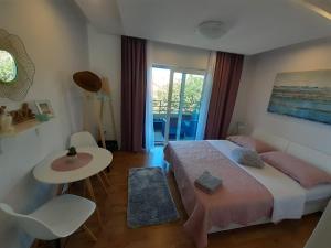 a bedroom with a bed and a table and a window at Barko apartment and rooms in Hvar