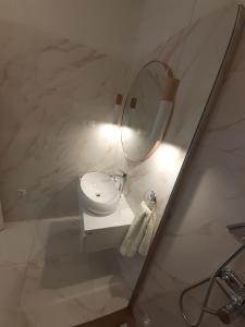 a white bathroom with a sink and a mirror at Barko apartment and rooms in Hvar