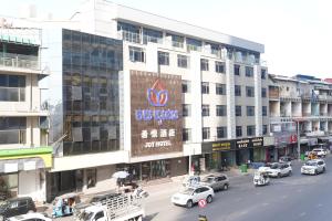 a city street with cars parked in front of a building at Joy Hotel in Phnom Penh