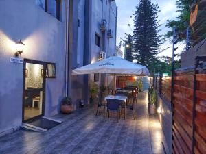 a table and chairs under an umbrella on a sidewalk at Stay Inn - Guest House in Maputo