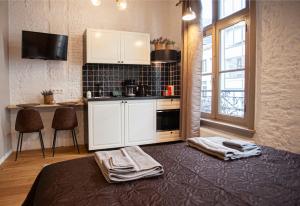 a kitchen with white cabinets and a table with towels at Luxury Suites Meir in Antwerp