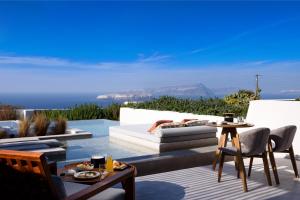 a patio with a white couch and a table at Potnia Theron Suites in Akrotiri