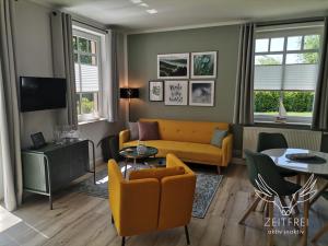 a living room with a couch and a table at ZEITFREI Urlaubsappartememts & Veranstaltungsort in Steffenshagen