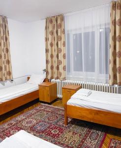a room with two beds and a window at Casa Zâna Bună in Gherla