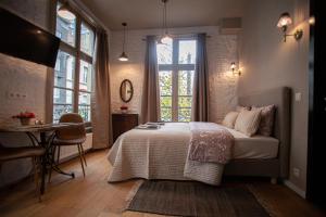 a bedroom with a bed and a table and a window at Luxury Suites Meir in Antwerp