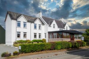 a white house with a black roof at Atholl House Skye in Dunvegan