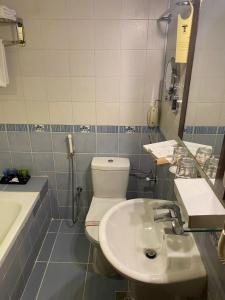 Saraya Harmony Hotel C في المدينة المنورة: حمام به مرحاض أبيض ومغسلة
