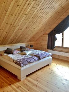 Ce lit se trouve dans un dortoir doté d'un plafond en bois. dans l'établissement Chata Natan, à Veľká Lomnica