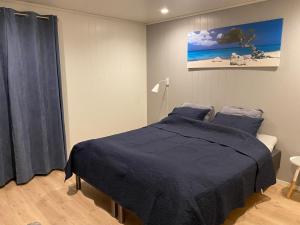 1 dormitorio con 1 cama con manta azul en Øvstefjellså Gård &Aktivitet Senter en Flekkefjord