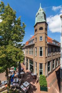 ein Gebäude mit einem Uhrturm darüber in der Unterkunft Hotel de Koppelpaarden in Lichtenvoorde