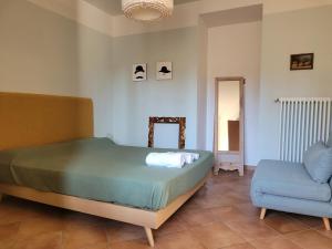 a bedroom with a bed and a blue chair at Il Pozzo in Tremezzo