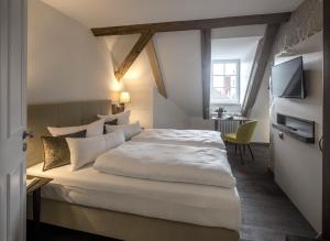 een slaapkamer met een groot wit bed in een kamer bij Altstadthotel der Patrizier in Regensburg