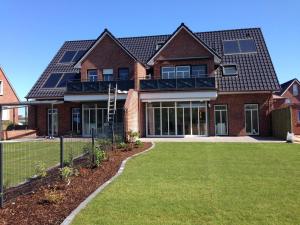 a large brick house with a lawn in front of it at Emsdüne in Borkum