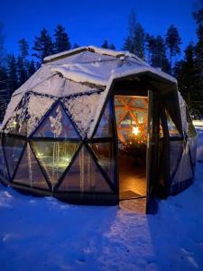 a dome tent in the snow at night at ForrestVila in Karačiūnai