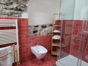 a bathroom with a toilet and a glass shower at Il Pozzo in Tremezzo