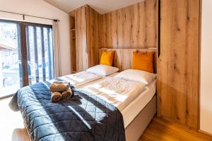 1 dormitorio con 1 cama grande y pared de madera en Max Relax, Ski in - ski out, en Zell am See