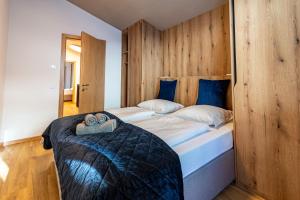 Max Relax SUMMERCARD INCLUDED Ski in-ski out في زيل أم سي: غرفة نوم بها سريرين توأم مع ألواح خشبية