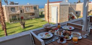 einen Tisch mit Tellern aus Essen auf einem Balkon in der Unterkunft Ayvalık Sea Resort in Ayvalık