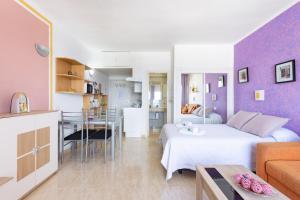 a bedroom with a white bed and a purple wall at Adeje Paraíso in Adeje
