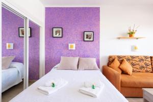 a bedroom with a white bed and a orange couch at Adeje Paraíso in Adeje