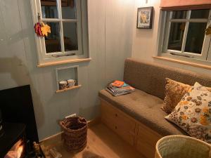 a tiny house with a bench and two windows at Chez Maurice Luxury Shepherds Hut with Bath and Hot Tub in Kelling