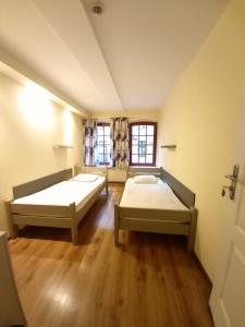 a room with two beds and a window at Hostel Orange in Toruń