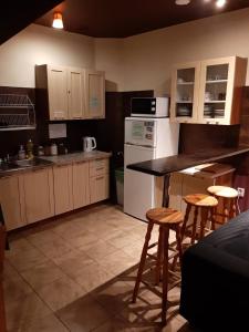 a kitchen with a counter and some stools in it at Hostel Orange in Toruń