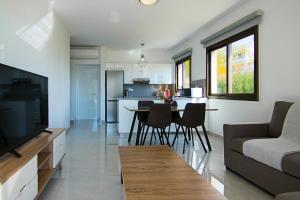 un soggiorno e una cucina con divano e tavolo di Phaedrus Living City View Luxury Flat Georgos 203 a Paphos
