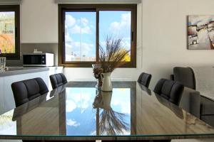 una sala da pranzo con tavolo in vetro e sedie di Phaedrus Living City View Luxury Flat Georgos 203 a Paphos