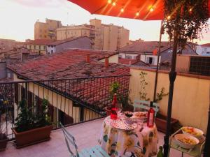 a table and chairs on a balcony with an umbrella at Da Coco e Mini,l'angolo per ceramiste in viaggio - in Faenza