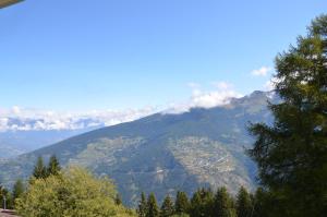a view of a mountain with trees and clouds on it at Immeuble Les Ecureuils in Les Collons