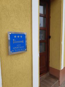 陶陶的住宿－Ady Apartman，门旁黄色墙上的蓝色标志