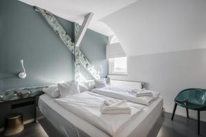 um quarto com uma cama branca e uma cadeira em Butik Apartments, by BQA em Budapeste