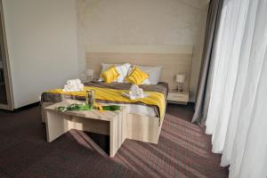 a bedroom with a bed with yellow sheets and a table at Hotel Bor in Krk
