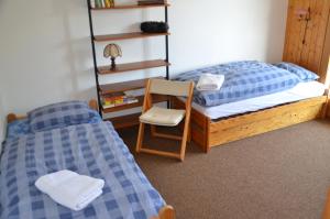 a bedroom with two twin beds and a chair at Immeuble Les Ecureuils in Les Collons